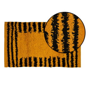 "Modern bathroom with a freestanding white bathtub and a bold yellow and black striped bath mat on a white tiled floor, complemented by floral wallpaper and elegant decor."