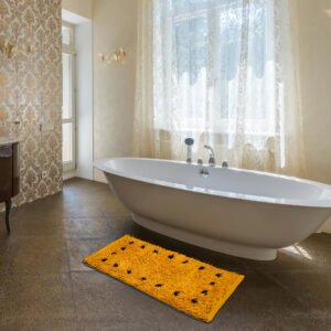 "Luxurious bathroom interior with a freestanding white bathtub and a bright yellow bath mat featuring black floral accents placed on a glossy tiled floor."